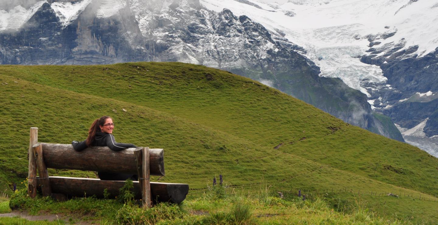 Student Nina on a bench in front of a mountain