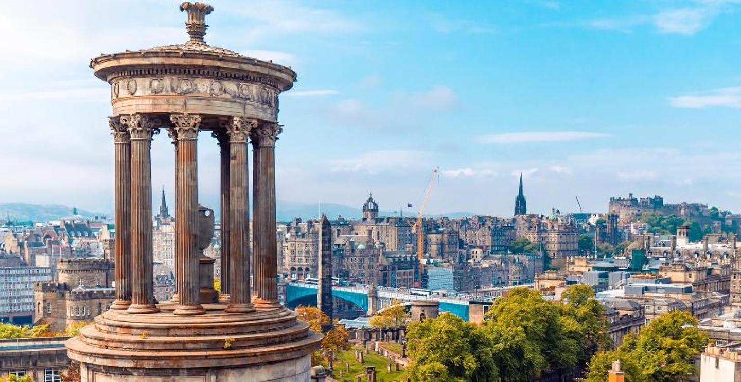 View of the skyline of Edinburgh, during daytime hours, with a tower in the foreground